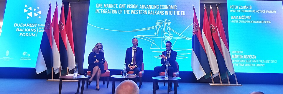 Three figures on stage meeting about extending the integration of the Western Balkans into the EU market.