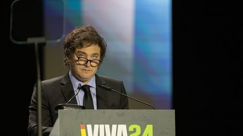 Javier Milei at podium with eyeglasses slipping down on his face.